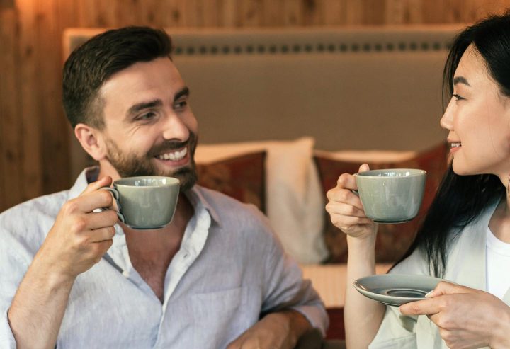A man and a woman drinking a cup of tea.