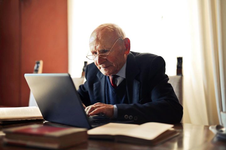 A smart elderly person working on a computer