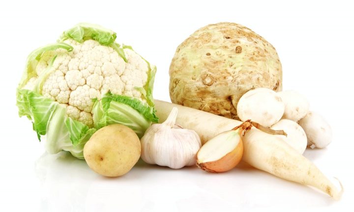 Arranjo de vegetais marrons e brancos, incluindo batata, couve-flor, cebola, alho, aipo, champignon e raízes.