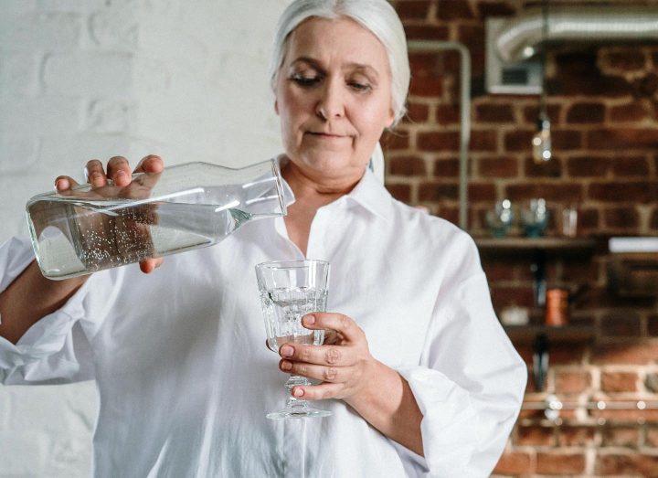 A senior woman getting a glass of water