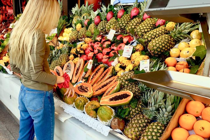 Uma mulher comprando no horti-fruti