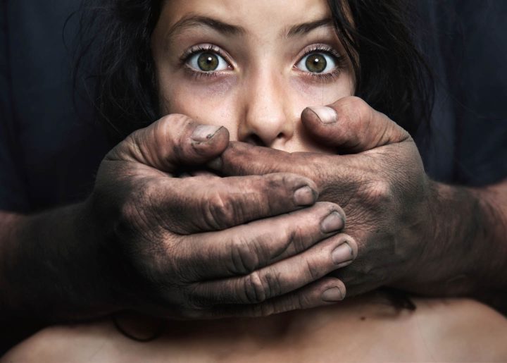 A girl being abused by the father and with mouth covered to remain silent