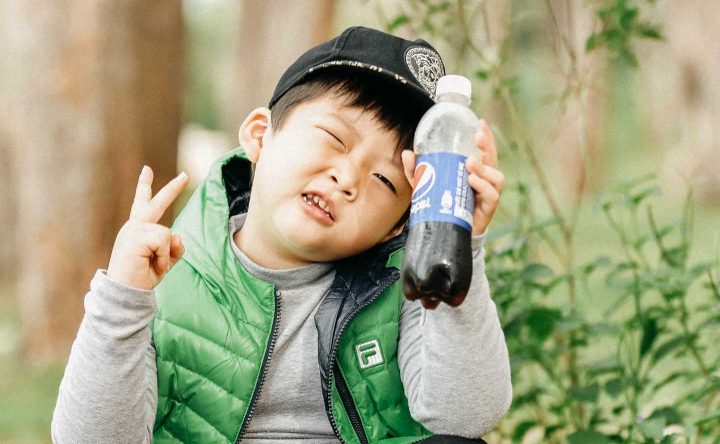 Uma criança consumindo um refrigerante