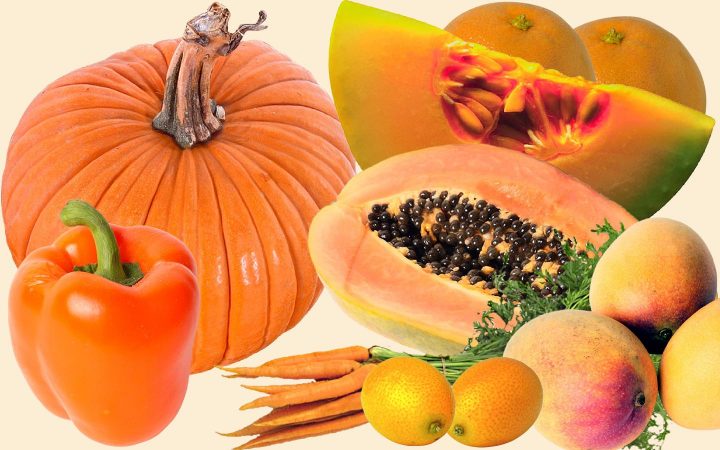 Assortment of orange fruits and vegetables including, pumpkin, cantaloupe, orange, carrots, mangoes and bell pepper.
