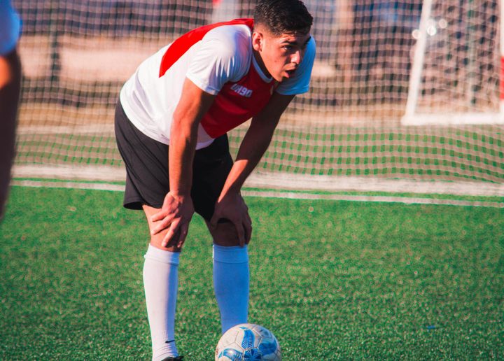 An exhausted soccer player exaggerating in his exercise levels