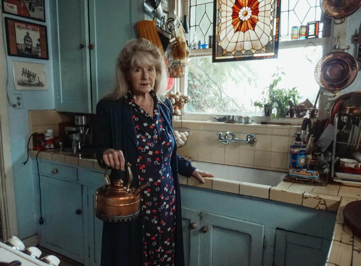 A senior woman making tea in her antique home