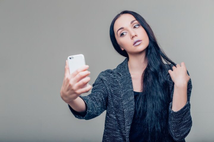 A girl worried about her appearance while posing for a selfie
