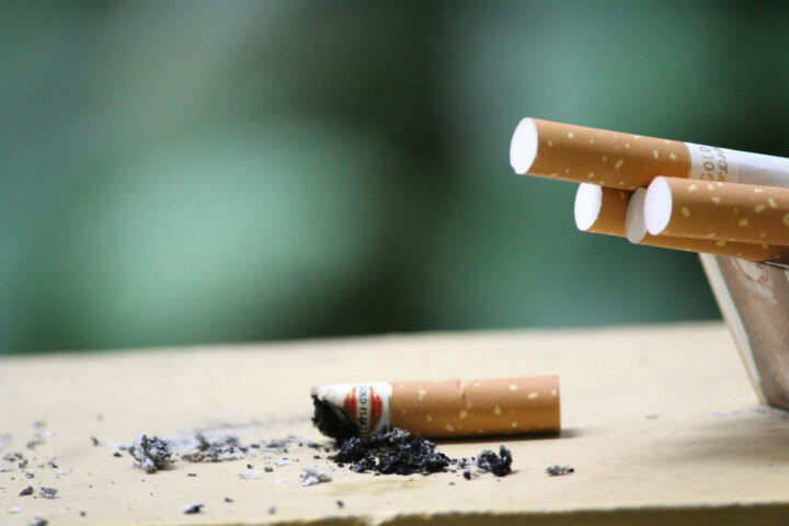 A smoked cigarette besides a pack