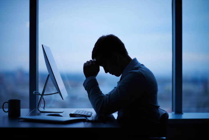 Stressed businessman sitting in front of computer in office