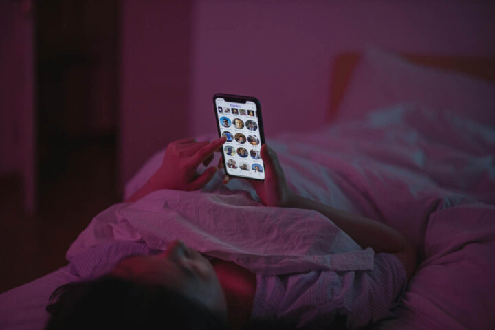 A woman using cell phone in bed and missing out on sleep