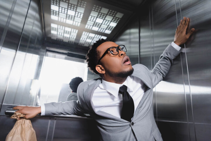 A businessman feeling phobia inside an elevator
