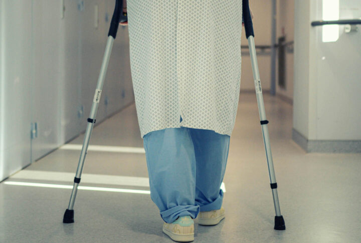 A man walking with crutches in the hospital