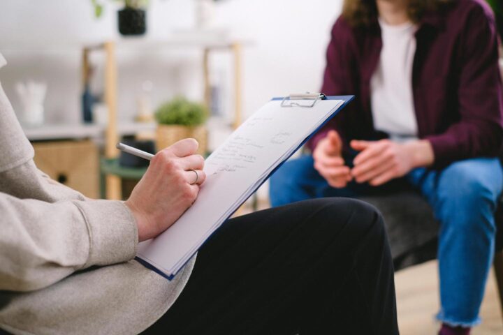 A psychologist making notes in a consultation