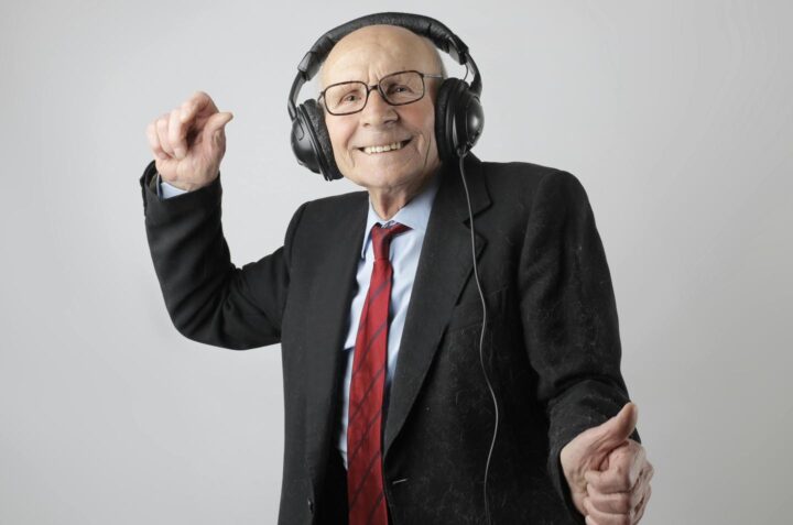 An elderly man enjoying a recording of music
