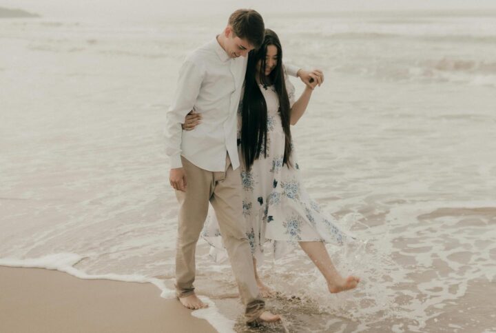 A couple walking on the beach being in their first love