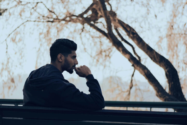 A pensive man sitting on a park bench