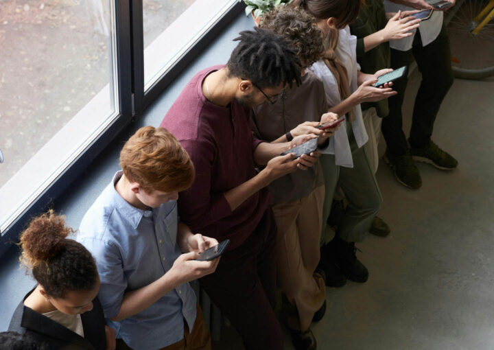 A group of young people all texting on their mobile phones