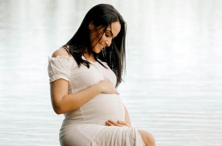 A pregnant woman looking at her body