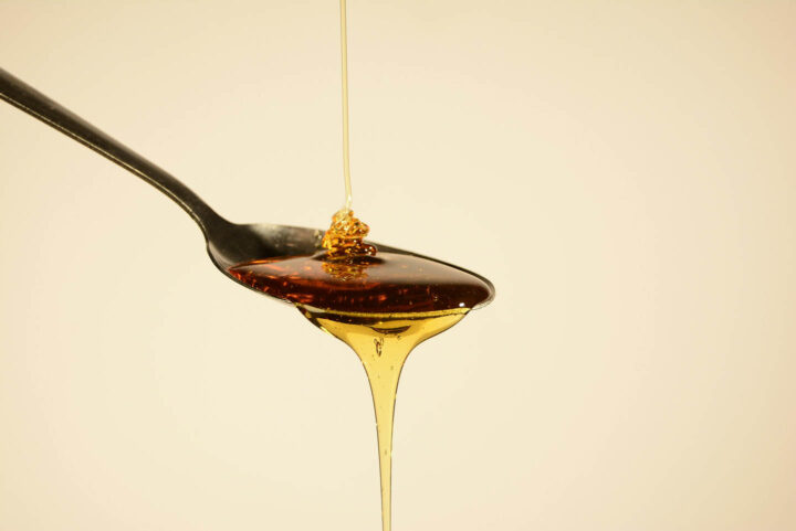 A sweetener like agave flowing from a spoon