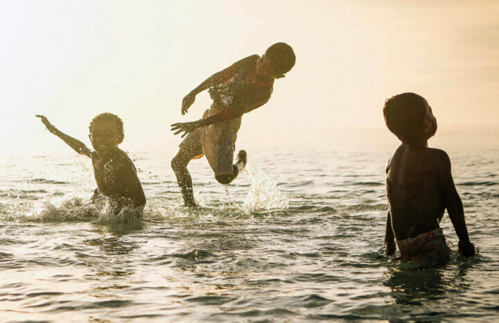 Children playing at the beach of a lake