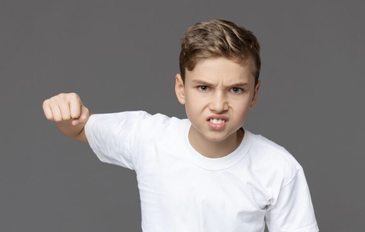 An agressive boy lifting a fist