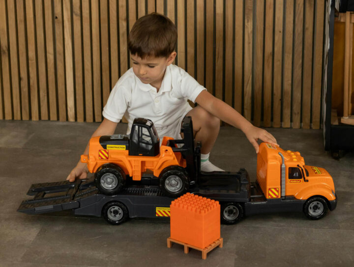 A boy playing with a toy truck