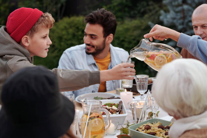 A boy being served flavored water at a family gathering
